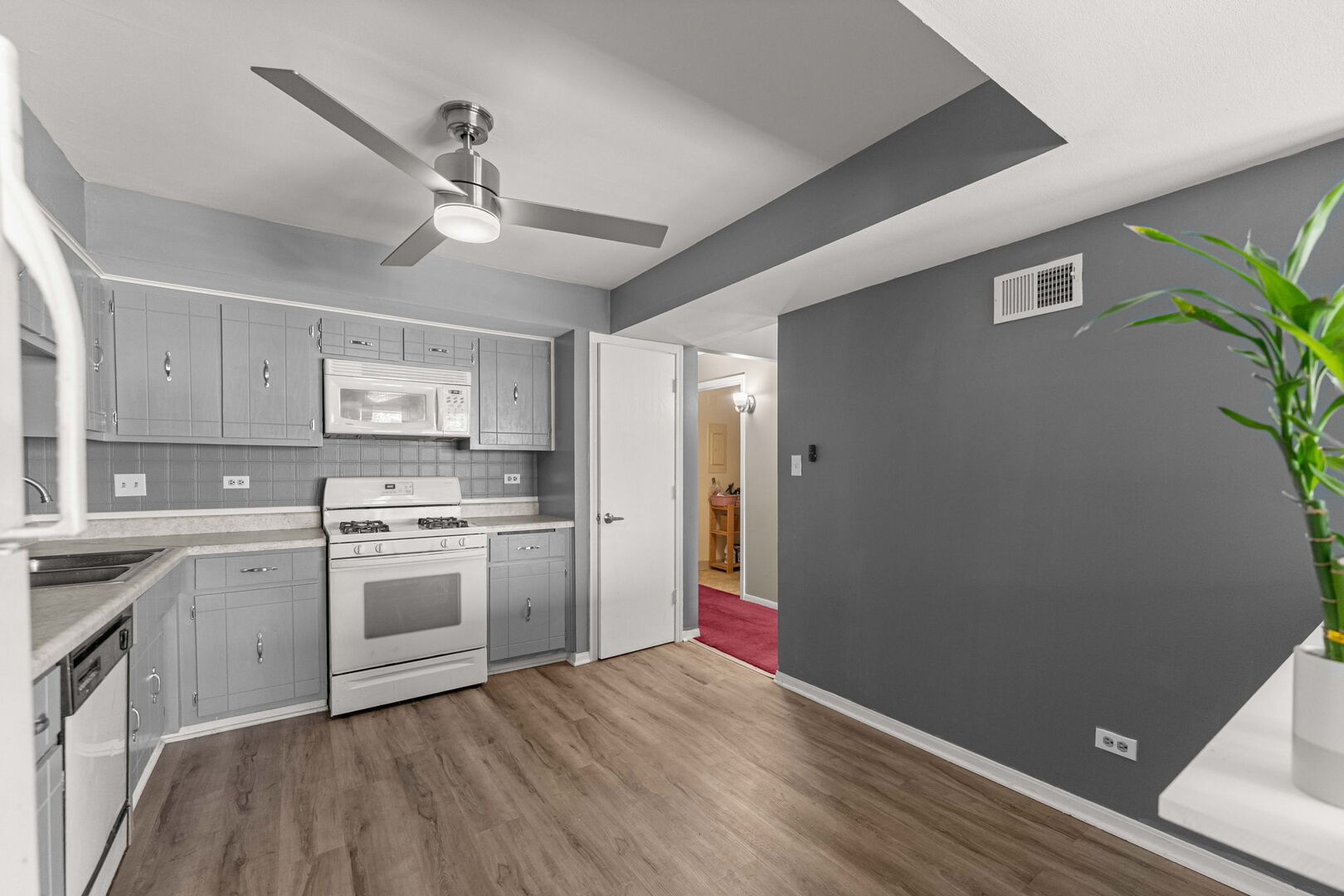 9122 South Pulaski Road, Unit 2E Oak Lawn, IL 60453 - Photo 4 of 16 a kitchen with stainless steel appliances granite countertop a refrigerator a sink dishwasher a stove and white countertops with wooden floor