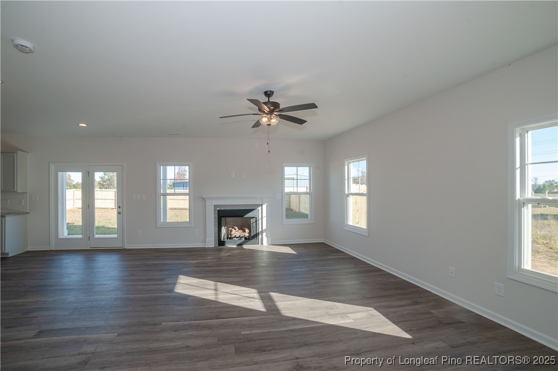 164 Ziggy Way Raeford, NC 28376 - Photo 11 of 25 an empty room with wooden floor a fireplace and windows