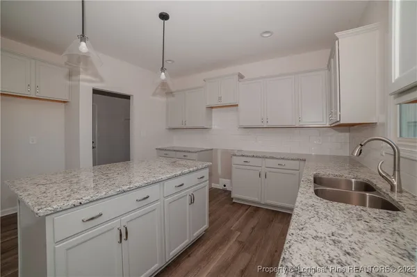 a kitchen with stainless steel appliances granite countertop a sink a stove a refrigerator and cabinets