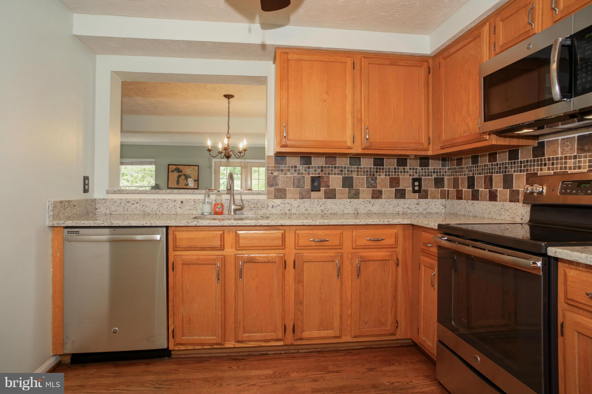 1595 Autumn Ridge Circle Reston, VA 20194 - Photo 3 of 26 a kitchen with stainless steel appliances granite countertop a sink stove and microwave