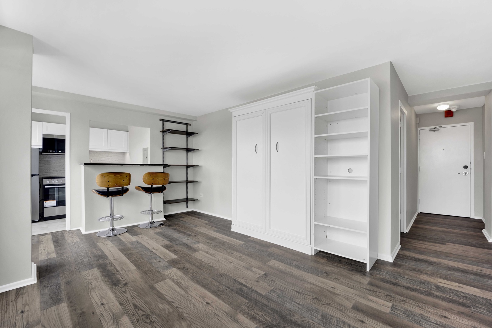 6030 North Sheridan Road, Unit 1307 Chicago, IL 60660 - Photo 6 of 18 a view of an empty room with wooden floor and a cabinet