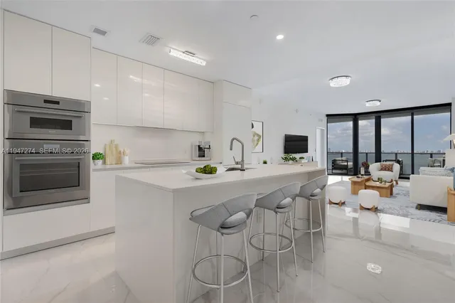 a view of an empty room with wooden floor and windows
