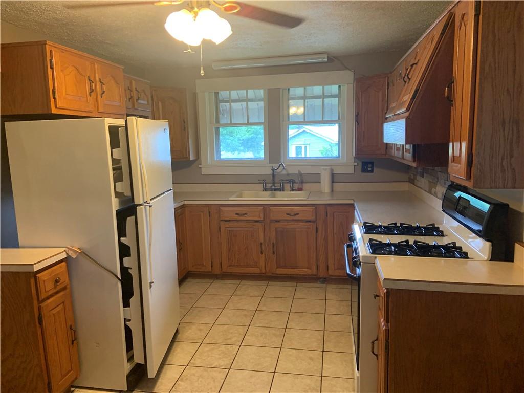 383 Chicora Road Butler, PA 16001 - Photo 8 of 24 a kitchen with a stove a refrigerator and a sink