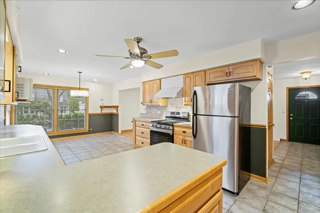 a kitchen with a refrigerator a stove top oven and a sink