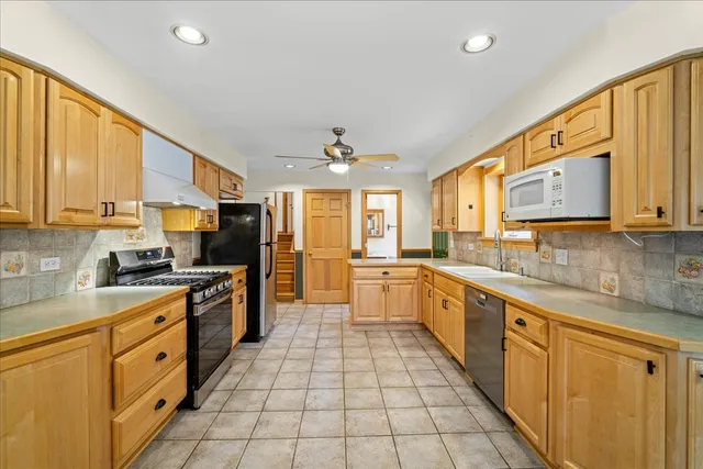 a large kitchen with stainless steel appliances lots of counter space sink and a microwave