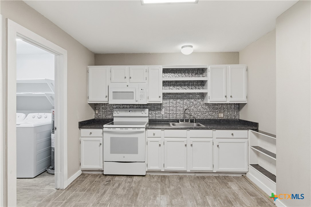 332 West Klein Street Seguin, TX 78155 - Photo 11 of 24 a kitchen with a stove cabinets and wooden floor