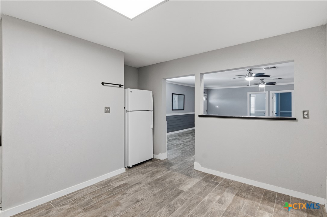 332 West Klein Street Seguin, TX 78155 - Photo 12 of 24 a view of a kitchen with a fridge and wooden floor