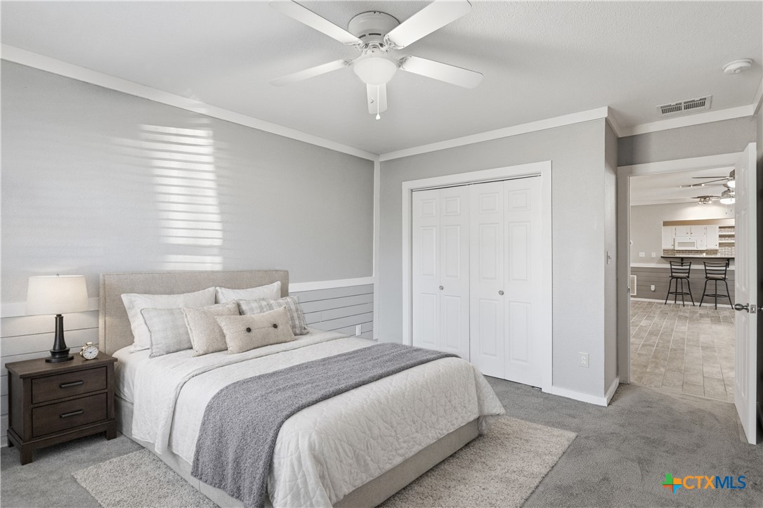 332 West Klein Street Seguin, TX 78155 - Photo 16 of 24 a bedroom with a bed and a chandelier