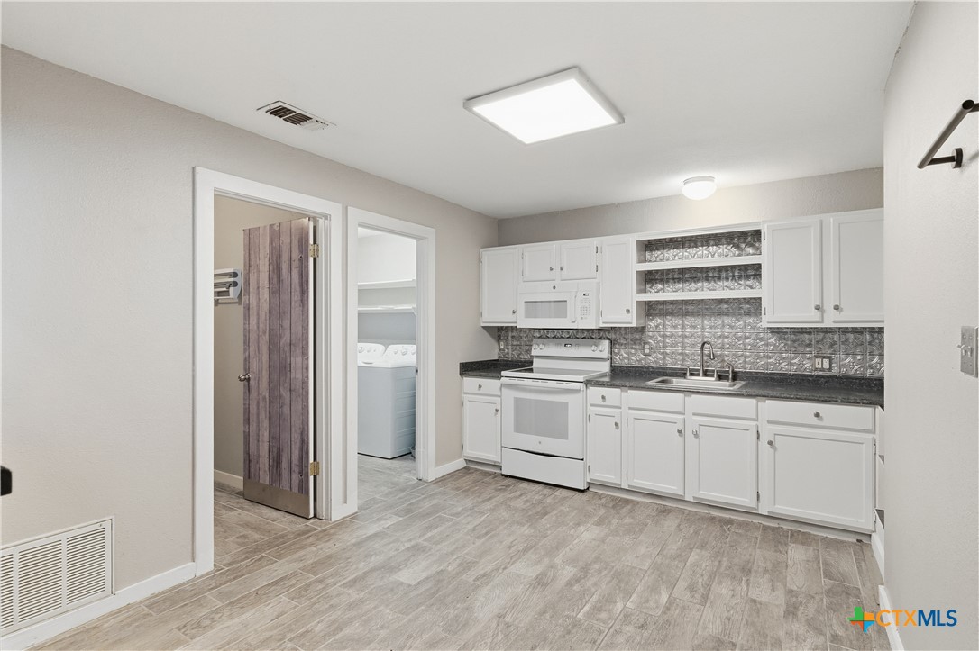 332 West Klein Street Seguin, TX 78155 - Photo 9 of 24 a kitchen with a sink stove and refrigerator