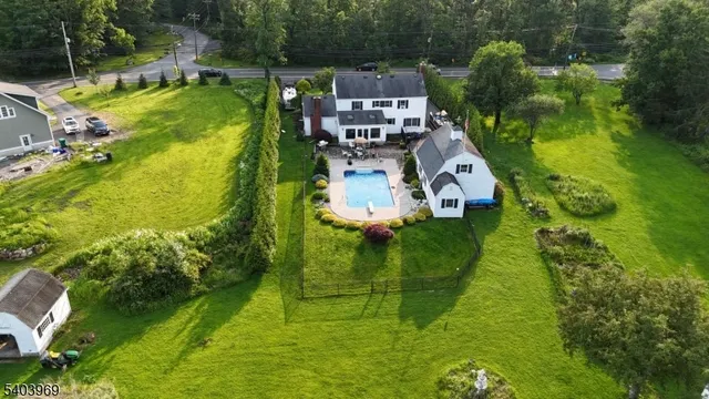 an aerial view of residential houses with outdoor space and trees