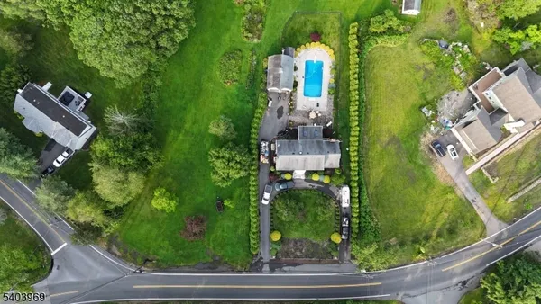 an aerial view of residential house with outdoor space and trees all around