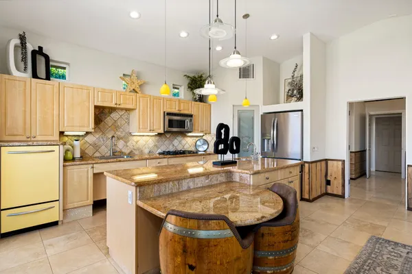 a kitchen with stainless steel appliances granite countertop a sink refrigerator and cabinets