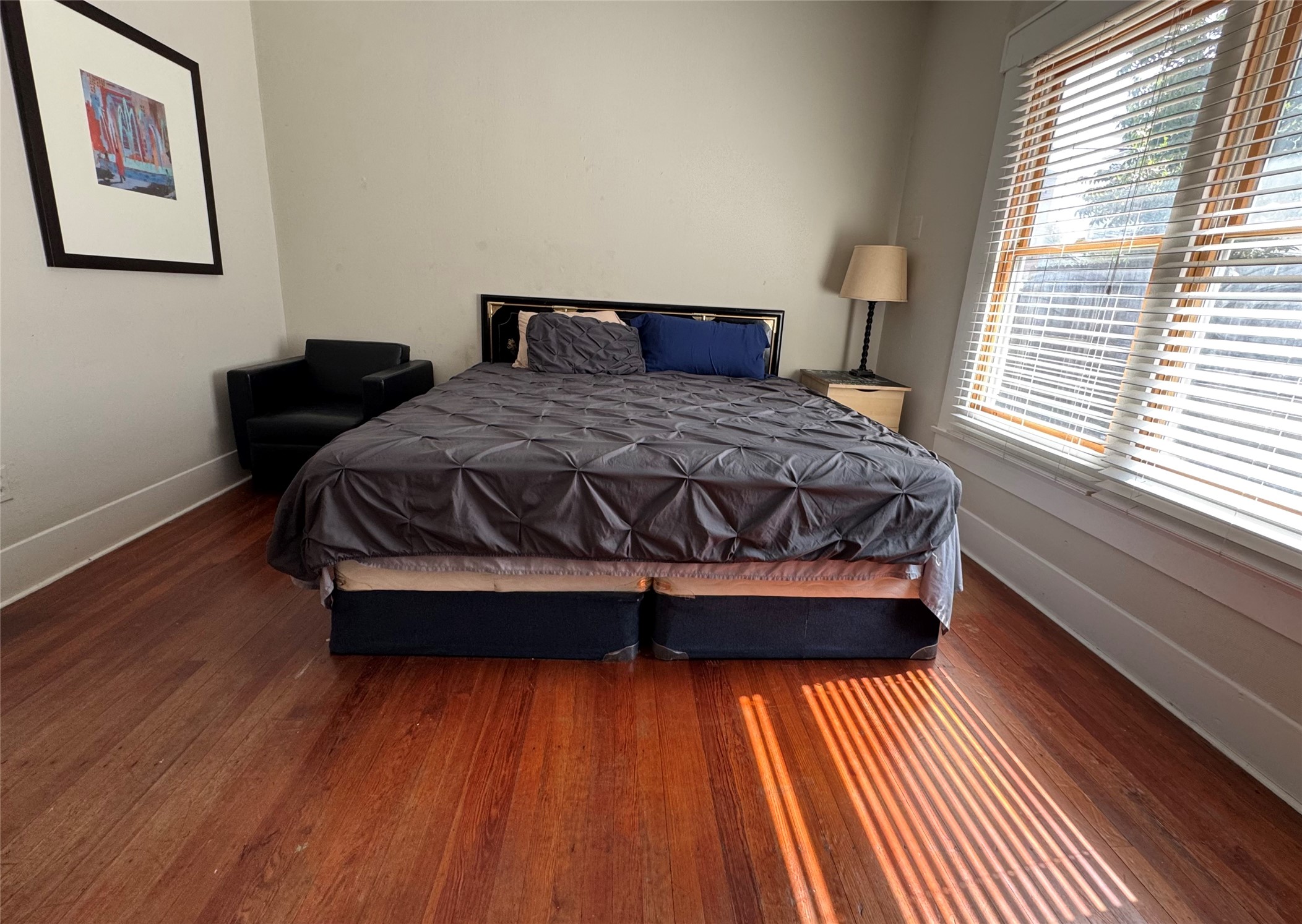 4204 Stanford Street Houston, TX 77006 - Photo 9 of 19 a bed sitting in a bedroom next to a window with wooden floor