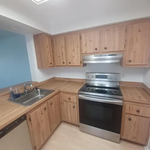 a kitchen with granite countertop white cabinets and a stove