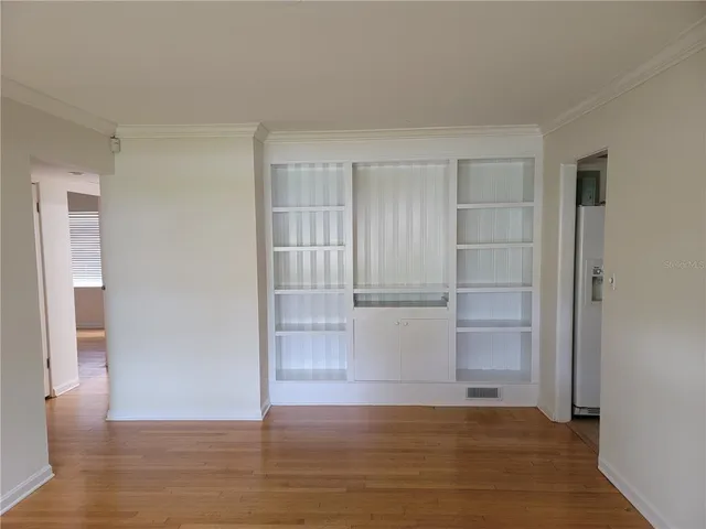 a view of empty room with wooden floor and cabinet