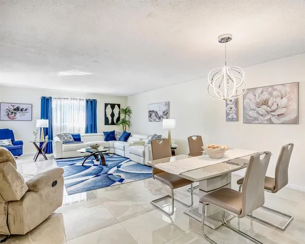 a living room with furniture a dining table and a chandelier