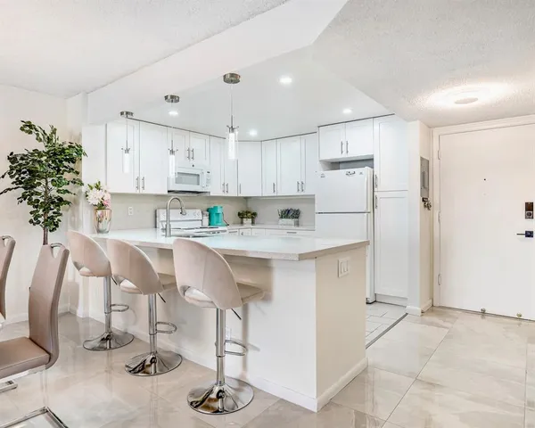 a kitchen with kitchen island granite countertop a sink cabinets and refrigerator