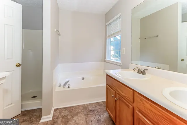 a bathroom with a tub sink and mirror