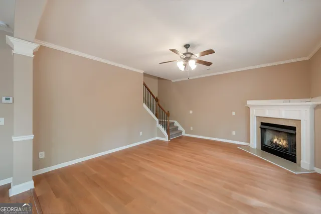 a view of an empty room with chandelier fan and fire place