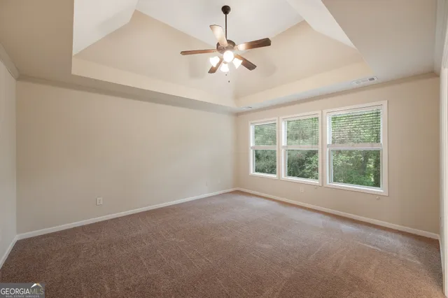 an empty room with a window and a fan