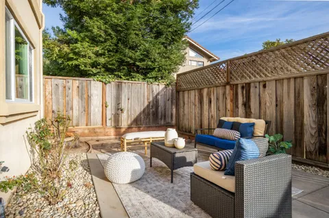 a view of a patio with couches and a table and chairs with wooden floor