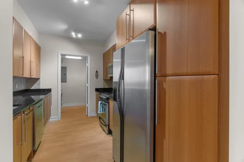 a kitchen with stainless steel appliances granite countertop a refrigerator and a stove