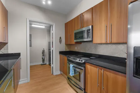 a kitchen with stainless steel appliances granite countertop a stove a microwave and a refrigerator