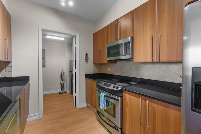 a kitchen with stainless steel appliances granite countertop a stove a microwave and a refrigerator