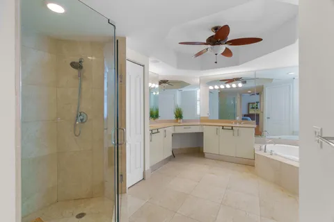 a large bathroom with a glass shower door a sink and a mirror