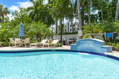 a view of a patio with a dining table and chairs with a fire pit and a large tree