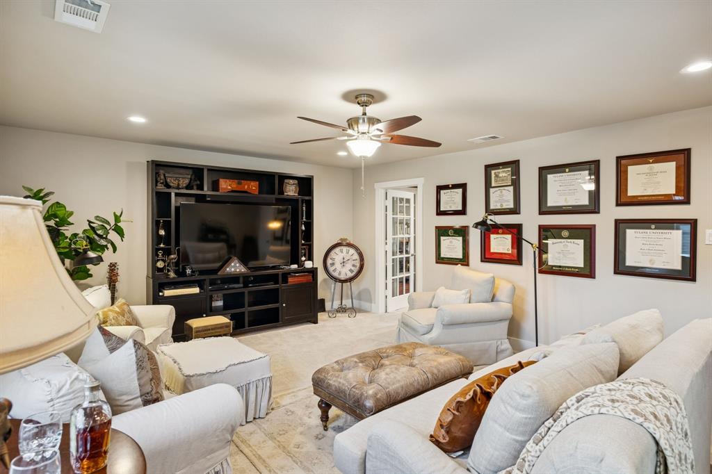 1309 Howell Street McKinney, TX 75069 - Photo 22 of 32 a living room with furniture a flat screen tv and a floor to ceiling window