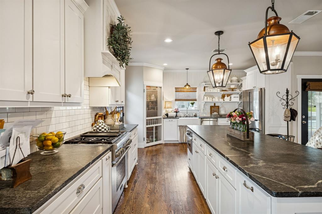 1309 Howell Street McKinney, TX 75069 - Photo 5 of 32 a kitchen with granite countertop a sink a counter space appliances and cabinets