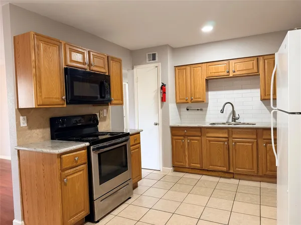 a kitchen with granite countertop cabinets stainless steel appliances and wooden floor