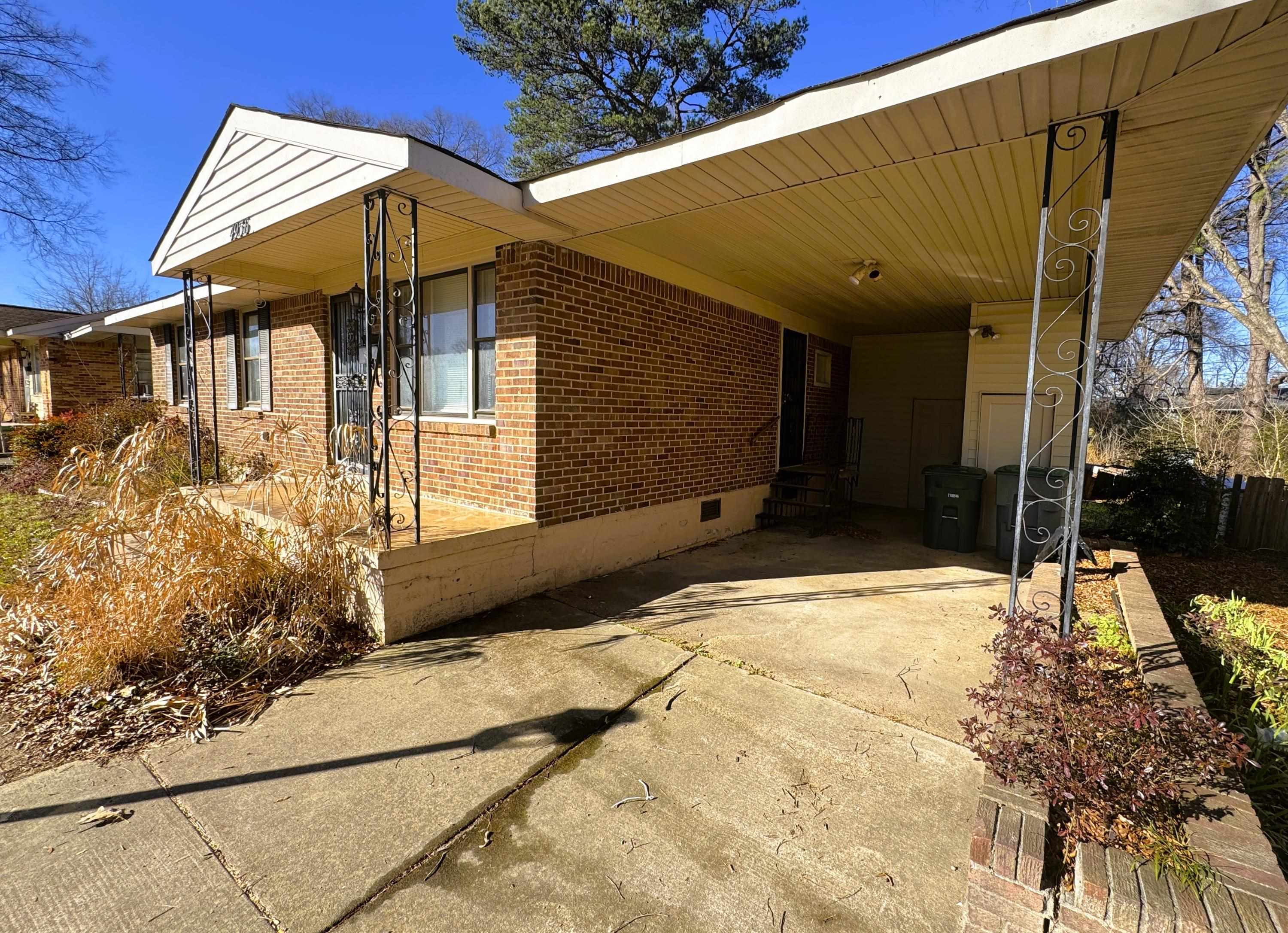 4956 Owen Road Memphis, TN 38122 - Photo 2 of 14 View of side of home featuring a carport, crawl space, brick siding, driveway, and a patio