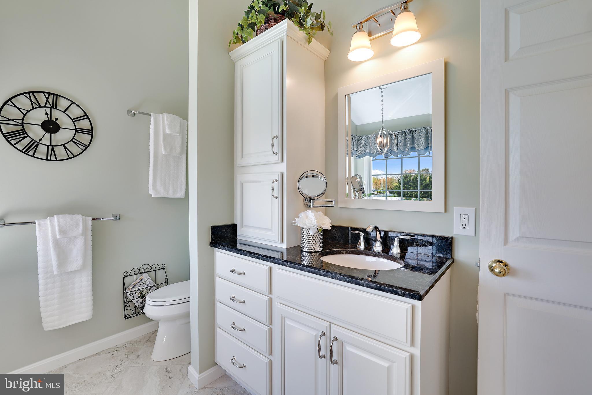 8301 Banister Road Severn, MD 21144 - Photo 37 of 57 a bathroom with a granite countertop sink a mirror a toilet and a window