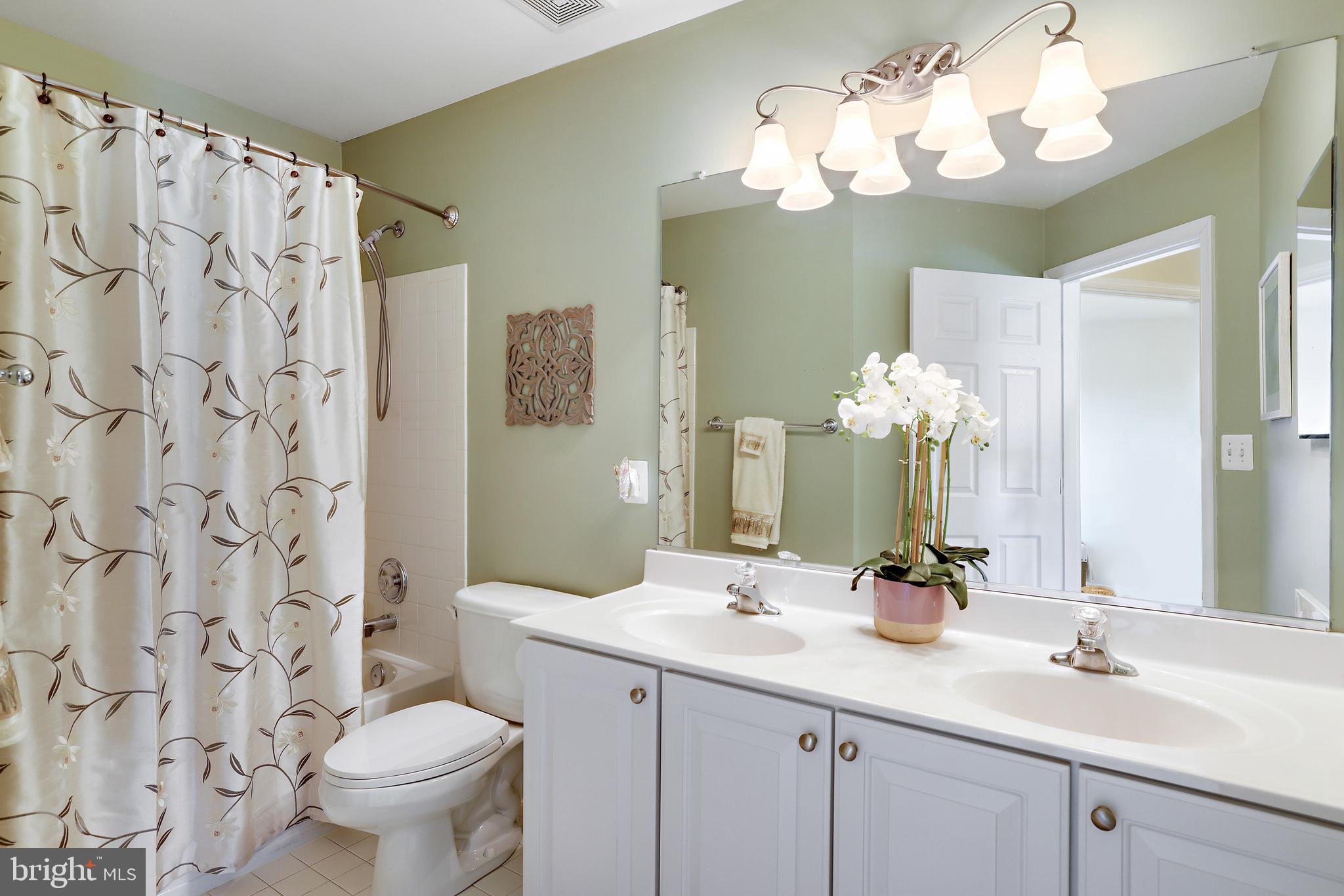 8301 Banister Road Severn, MD 21144 - Photo 44 of 57 a bathroom with a double vanity sink mirror and toilet