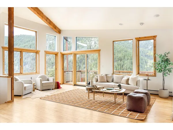 a living room with furniture and floor to ceiling windows