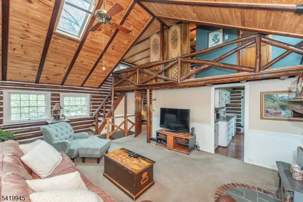 a living room with furniture a flat screen tv and a window
