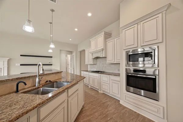 a kitchen with kitchen island granite countertop a sink a counter top space and cabinets
