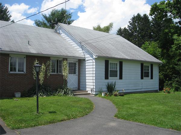 a front view of house with a garden and patio