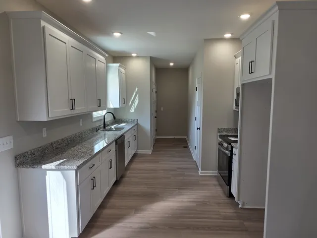 a kitchen with stainless steel appliances granite countertop a refrigerator and a sink