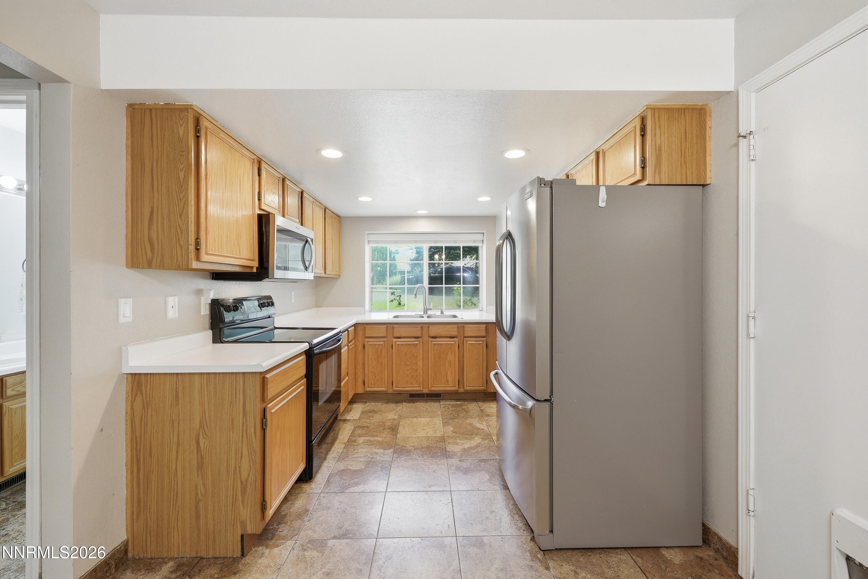 1899 Tuolumne Drive Reno, NV 89523 - Photo 13 of 44 a kitchen with stainless steel appliances granite countertop a refrigerator and a stove top oven