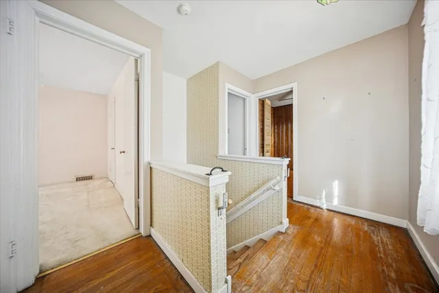 a view of a room with wooden floor and a bathroom