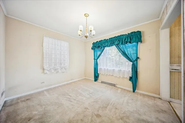 an empty room with windows and chandelier