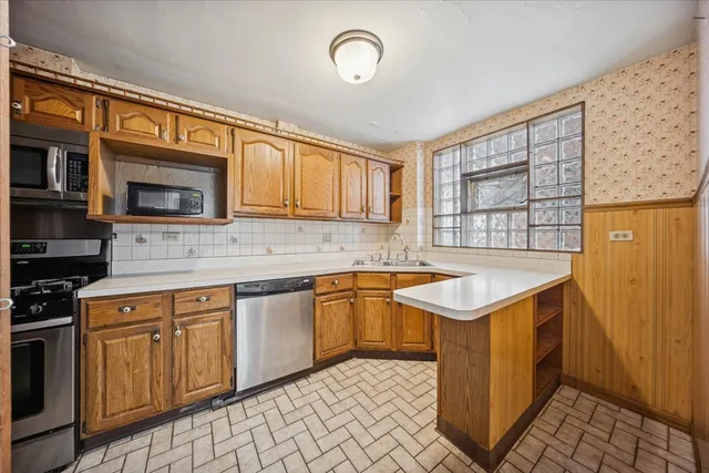 a kitchen with stainless steel appliances granite countertop a stove a sink and a microwave