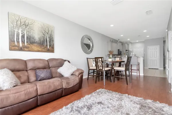 a living room with furniture wooden floor and dining table