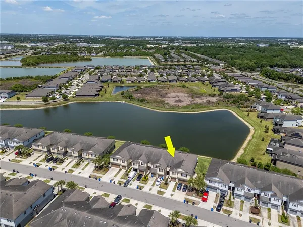 an aerial view of a city with lots of residential buildings and ocean view in back