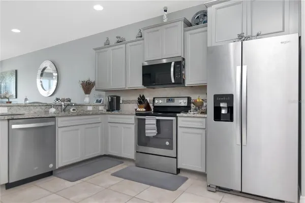 a kitchen with stainless steel appliances granite countertop a refrigerator sink and stove