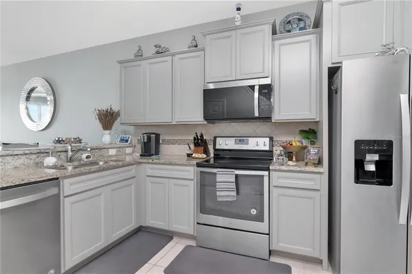 a kitchen with stainless steel appliances granite countertop a refrigerator sink and stove