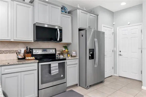 a kitchen with stainless steel appliances a refrigerator stove and white cabinets